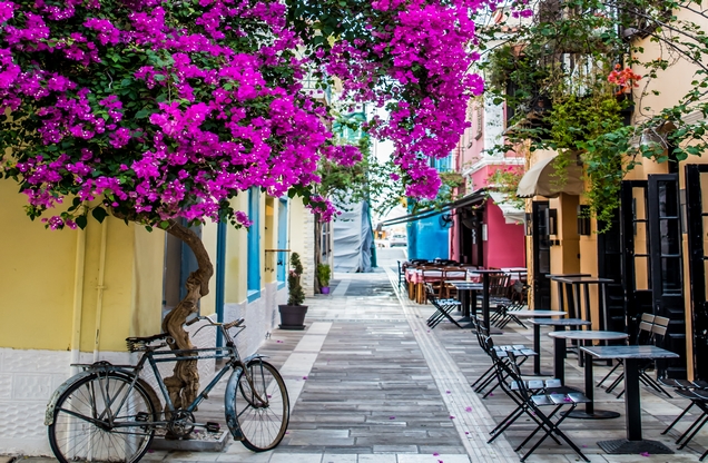 stone alley with blooming purple trees in Nafplion City