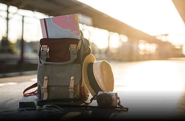 Tailor Made Tours: a travel backpack with a map and a hat tucked next to it