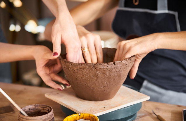 hands sculpting a ceramic utensil
