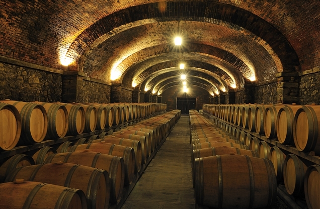 illuminated cellar with wooden wine barrels in Nemea