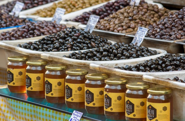 jars of honey and baskets of olives at the central market of Athens