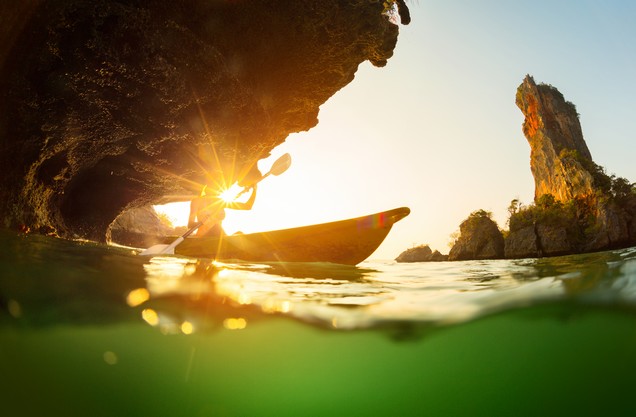 the sun through the sea water and a canoe