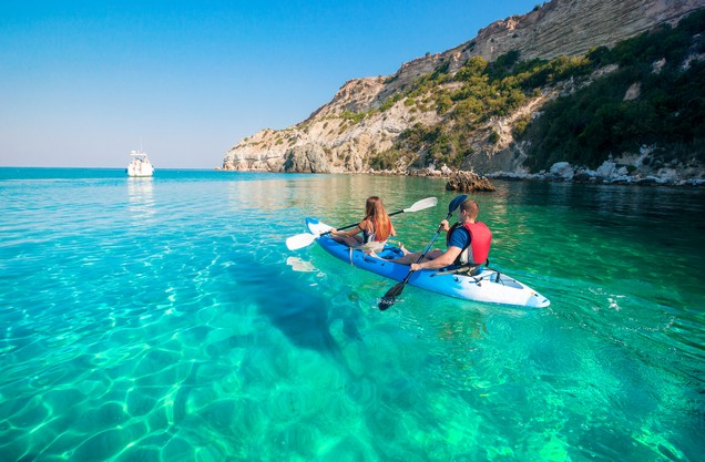 two people kayaking in the blue waters of the Kardamili Sea