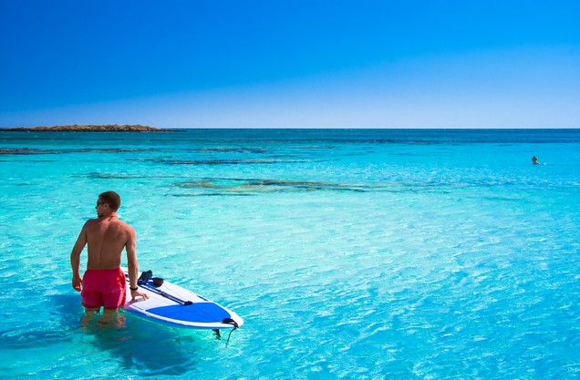 SUP & Snorkeling in Kardamili: a man with his SUP board in the blue waters of Kardamili