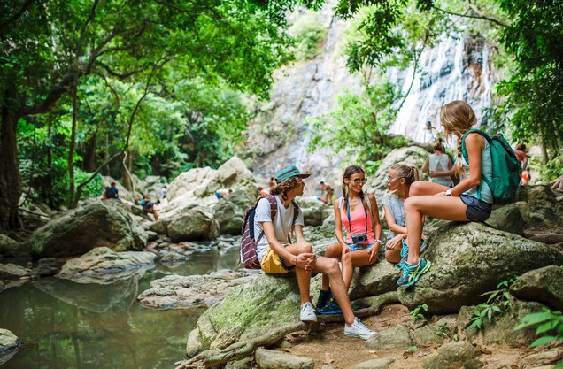 River Hiking & Archery in Polilimnio waterfalls: Hikers sit on the rocks next to the running waters in the Polyimnion Gorge