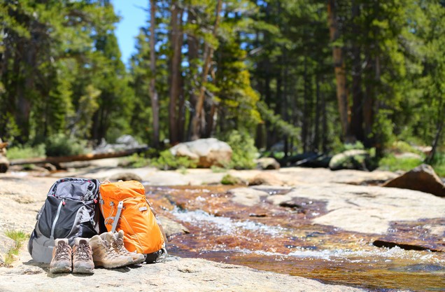 River Trekking in Neda gorge: hiking backpacks resting on the banks of the Neda River