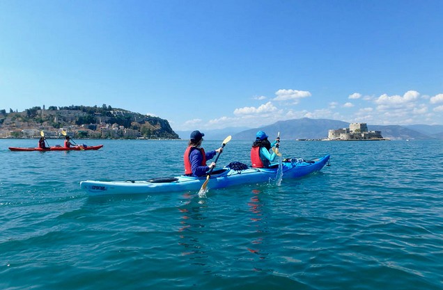 people doing kayak in front of the medieval castles of Nafplio